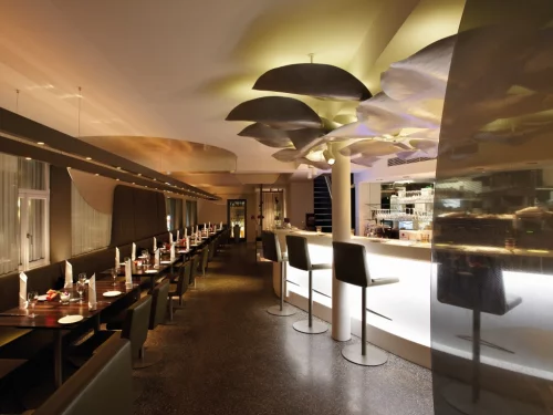 Ein stilvolles Restaurant mit moderner Beleuchtung und Sitzgelegenheiten. (KI generiert)