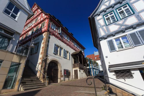 Historische Gebäude mit Fachwerkfassaden, Treppen und Kopfsteinpflasterstraße. (KI generiert)