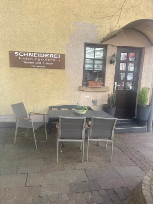 Schneiderei mit Änderungsservice für Damen und Herren, Innenbereich mit Tischen und Stühlen. (KI generiert)