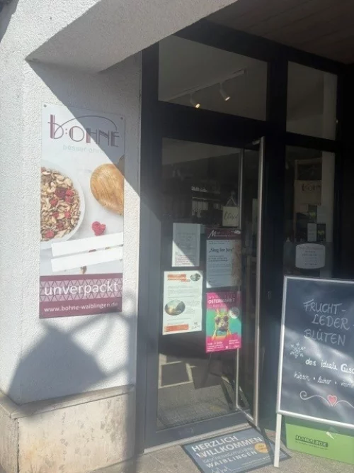 Ladenfenster mit "Bohne" Schriftzug, Obstangebot und Begrüßungstext (KI generiert)
