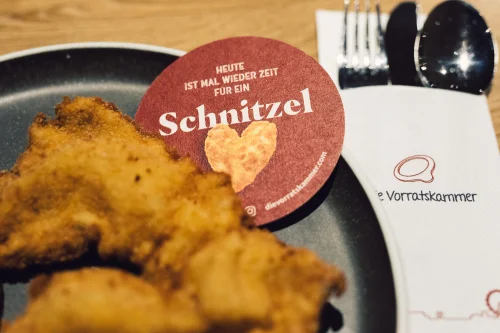 Gebratenes Schnitzel auf einem Teller mit Kartoffelpüree und Salat. (KI generiert)